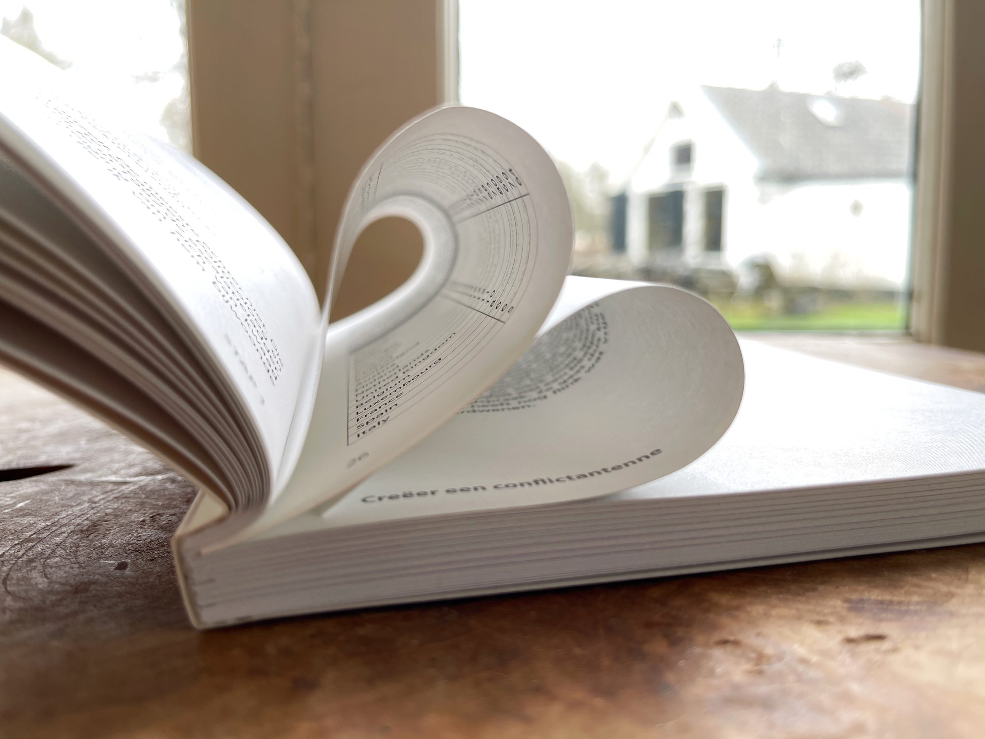 Opengeslagen boek met tot een hart gevouwen pagina’s